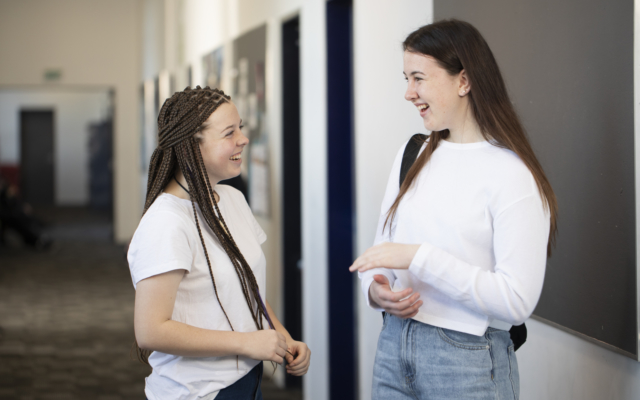 Two students in a school hallway