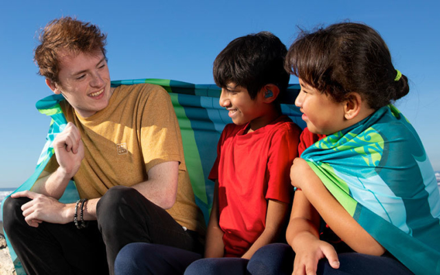 Students sitting on beach